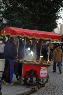 İstanbul (Türkiye) Aralık 2021: Kestane satıcısı (düşey) İstambul sokaklarında tipik bir koçan satıcısı)