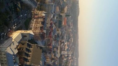 Dikey video. Ukrayna 'nın Lviv şehrinin üzerinde uçuş. Akşamın batışında şehrin eski kısmı..