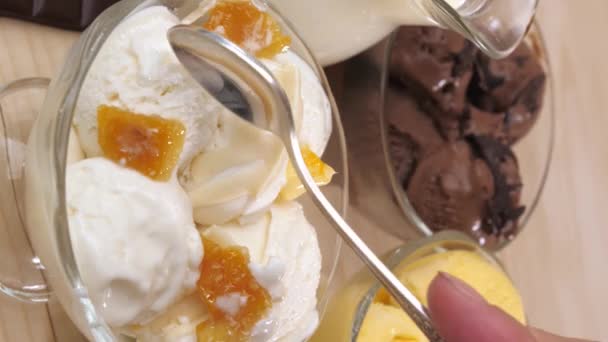 垂直录像 三瓶装有香草 巧克力 芒果和香蕉味的冰淇淋球的玻璃瓶 一个女人的右手用茶匙放下来吃香草冰淇淋 — 图库视频影像