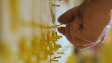 Dikey video. Seramik fayanslar yerleştiriliyor. Parçaları ölçüyor ve kesiyor. İşçi seramik fayanslar arasına plastik haçlar yerleştirir.