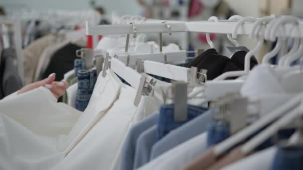 Šaty Visí Ramínkách Obchodě Žena Ruce Vybrat Bílé Kalhoty Před — Stock video
