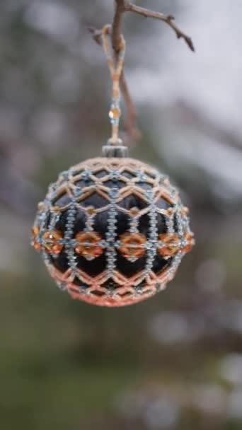 垂直录像 用金黄色珠子装饰的黑色光滑的圣诞树玩具挂在树枝上旋转着 — 图库视频影像