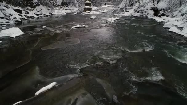 在多云的一天 飞越一条湍急流淌的高山冬季河流 冬季景观 — 图库视频影像