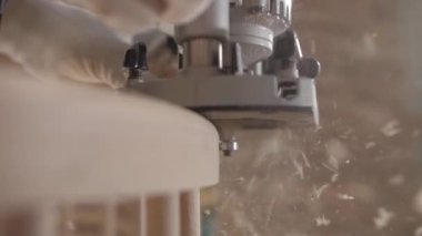 A carpenter mills the edges with sawdust flying everywhere. Carpenter works with a manual electric milling cutter.