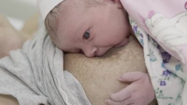 Yeni doğmuş bir kızın ilk beslenmesi. Bebek anne göğsünden süt emer. Yakın plan..