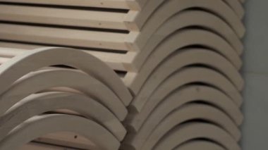 Many wooden parts for furniture lie in the workshop. Production of beds. Woodworking.