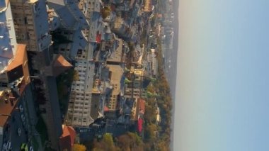 Dikey video. Ukrayna 'nın Lviv şehrinin üzerinde uçuş. Akşamın batışında şehrin eski kısmı. Drone görünümü.