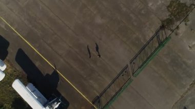 A spinning aerial view. The shadow of the young woman and the shadow of the man approach each other and begin to kiss.