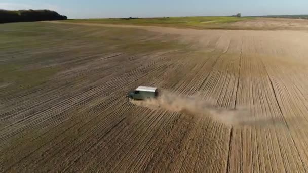 ルツク ヴォリン ウクライナ 2019年10月19日 緑のランドローバーディフェンダーSuvは 穀物の種類の植物で植えられた耕されたフィールドを通って駆動します 空中展望 車の後ろにはほこりがたくさんある — ストック動画