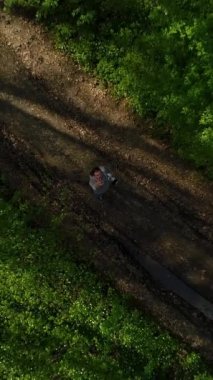 Dikey video. Genç adam elini kaldırdı ve İHA 'sı bahar ormanının üzerinden uçtu. Güneş sistemi bir buluta dönüştü. Hava görünümü
