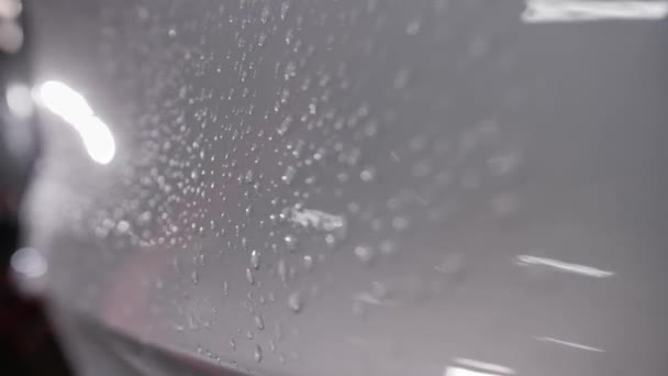 Близько Краплі Води Сірій Глянсовій Поверхні Кузова Автомобіля Рука Камери — стокове відео