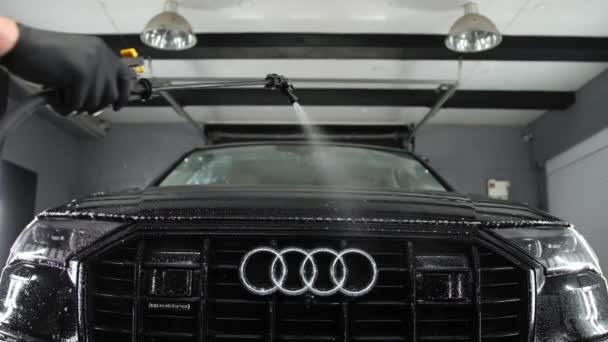 ルツク ヴォリン ウクライナ 2023年6月10日 Audi 現代の黒い車の汚れたフロントに洗剤を噴霧 ヘッドライト ラジエーターグリルと泡のエンブレム 洗車場でのサービス — ストック動画