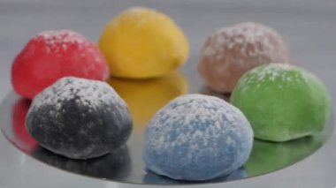 Karamel, armut, ahududu, erik, mango ve fıstık aromalı altı mochi keki ayna yüzeyinde yatarken dönüyor. Japon geleneksel mutfağı.