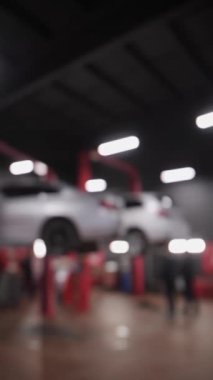 Dikey video. Tamirci Araba Tamirhanesi ve Servis İstasyonundaki Arabalar için Elektrikli Asansör. Aracı olan elektrikli asansör. Odaklanmamış video