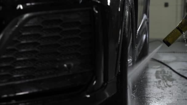 靠近点昂贵级别的黑色跑车的合金轮在洗车处用高压洗衣机清洗 — 图库视频影像