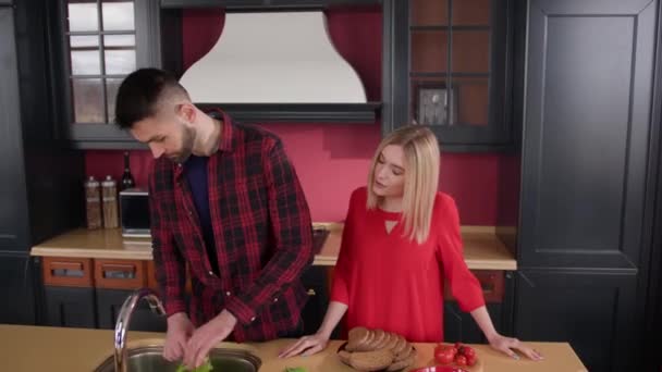 Młoda Kobieta Flirtuje Młodym Mężczyzną Kuchni Facet Wyciąga Liście Sałaty — Wideo stockowe