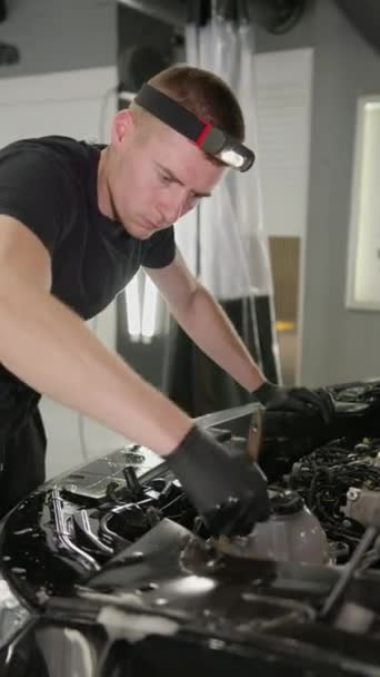バーティカルビデオ 労働者は石鹸の泡が付いているブラシに集中し 車のエンジン要素を洗います コンセプトを詳述する車両 — ストック動画
