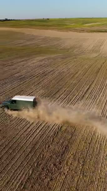 ルツク ヴォリン ウクライナ 2019年10月19日 垂直ビデオ グリーンランドローバーディフェンダーSuvは 穀物の種類の植物が植えられた耕された畑を駆動します 車の後ろにはたくさんの塵があります — ストック動画
