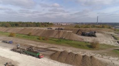 Dikey video. Traktör ve şeker pancarı dolu bir kamyon. Tarım endüstrisindeki tatlı kökleri boşaltma ve taşıma. Hava görünümü.