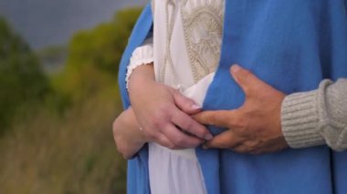Yaşlı bir adamın kollarını bir kadına dolaması. Emeklilik çağında aile mutluluğu kavramı.