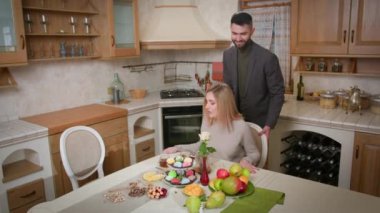 Genç bir esmer adam ve sarışın bir kadın masaya oturmuş meyveli bir tatlı, renkli mochi kekleri ve fincanda çay ile birlikte. Romantik olay kutlaması kavramı.