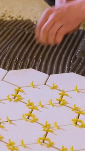 Вертикальне Відео Працівник Встановлює Пластикові Хрести Між Керамічною Плиткою Своїми — стокове відео