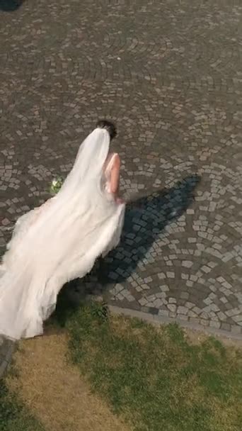 Függőleges Videó Menyasszony Fehér Esküvői Ruhában Csokorral Kezében Sétál Ősi — Stock videók
