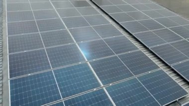 Hava görüntüsü. Çatıdaki fotovoltaik güneş panelleri üzerinde uçuyor. Kapatın. Temiz ekolojik elektrik üretimi. Yenilenebilir enerji üretimi kavramı.