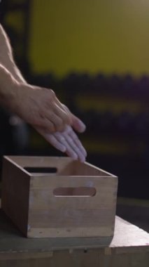 Dikey video. Tebeşir manyezi tozu el çırpıyor. Magnezyum tozu el tebeşiri. Spor salonu genç yetişkin erkek dayanıklılık çabası. Siyah arka planda vücut geliştirme uzmanları.