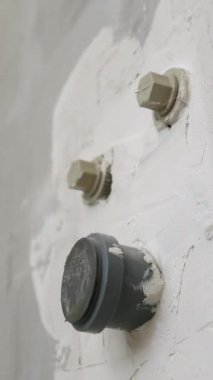 Dikey video. Soğuk ve sıcak su tedarik etmek için plastik borularla sıvanmış duvarın yanı sıra kanalizasyon boruları. Hepsinin fişi var. Tamir ve yeni tesisat kavramı.