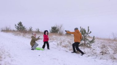 Üç kişilik genç bir aile karlı bir havada kartopu oynuyor. Baba, kızı ve karısı tarafından fırlatılan kardan komik bir şekilde kurtuluyor. Kış aktif eğlence.