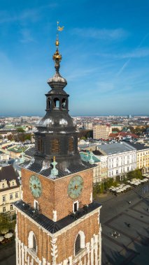 Bir şehirde üzerinde saat olan bir saat kulesi gösterilir..