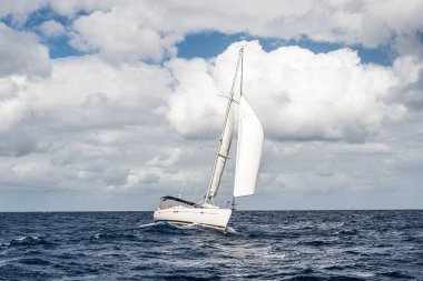 Yacht sailing fast on wild sea with waves in Italy, Mediterranean