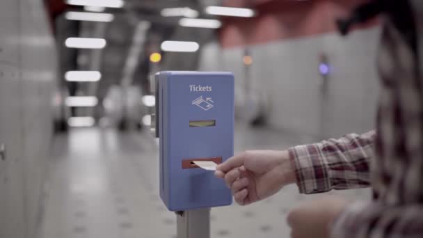 ドイツのミュンヘンの交通システムの検証のためにマシン内のチケットを検証する男 公共交通機関 人は時間スタンプのための検証機に紙チケットを挿入します — ストック動画