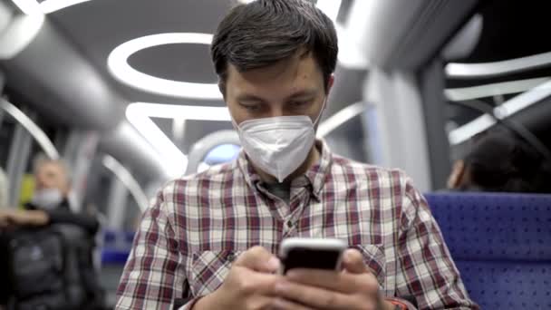 使用智能手机和戴口罩上下班的人在公共交通上工作 新的正常 蒙面乘客乘坐地铁旅行 并用他在慕尼黑的智能手机上网 Internet — 图库视频影像