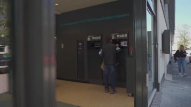 20 Eylül 2022. Münih. Almanya. Erkek, plastik atıkları Aldi süpermarketindeki geri dönüşüm makinesine geri gönderir. Adam şişeyi otomatik şişe geri dönüşüm makinesine koyar. Geri dönüşüm otomatını tersine çevir. 