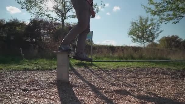 在德国的一个公园里 穿着运动鞋的人在平衡橡胶绳的基础上学习走路和保持平衡 娱乐和健康积极的生活方式概念 在松驰线上的室外初余额 — 图库视频影像