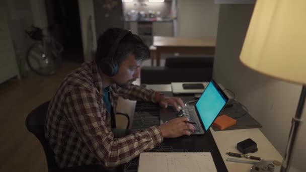 Bilgisayarında Kulaklıkla Çalışan Akşamları Elinde Kalemle Alan Bir Erkek Öğrenci — Stok video