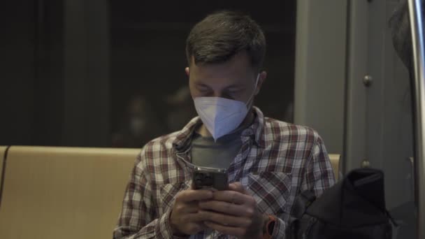Hombre Enmascarado Caucásico Utiliza Teléfono Inteligente Mientras Está Sentado Espaldas — Vídeo de stock