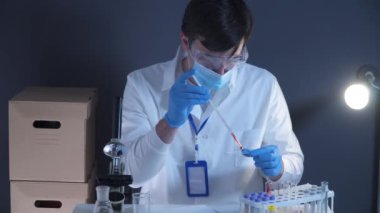 Laboratuvarda kan örnekleriyle çalışan bir patolog. Bilimadamı DNA örneğini laboratuvarda inceliyor. Sağlık sigortası, kan testi, kan araştırması. Laboratuvar çalışanı kan örnekleriyle slayt hazırlıyor.. 