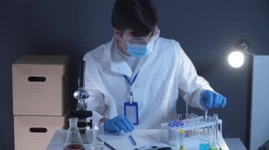 Laboratuvarda kan örnekleriyle çalışan bir patolog. Bilimadamı DNA örneğini laboratuvarda inceliyor. Sağlık sigortası, kan testi, kan araştırması. Laboratuvar çalışanı kan örnekleriyle slayt hazırlıyor.. 