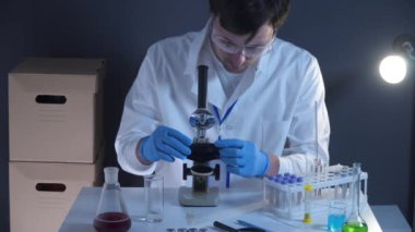 Laboratuvarda kan örneğiyle çalışan bir bilim adamı. Laboratuar analisti kan kaymasını analiz ediyor. Doktor ya da patolog cam levhaya insan kanı döker. Virüsü tanımlamak için biyolojik materyal.. 