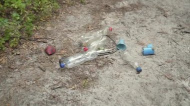 Orman yolunda plastik atık yığını. Yolda plastik şişeler var. Ormanda doğada çöp toplama. Çöp öğütücü. Çevresel koruma. Dünya ekolojisi problemi. Kirlilik kavramı. 