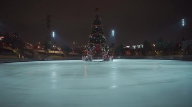 Noel buz pateni pistinde, karantina pandemik koronavirüs sırasında köknar ağacı boş ve Ukrayna, Kiev 'de akşam saatlerinde covid 2019. Geceleri buz pateni pisti. Buz pateni için boş kamusal alan.
