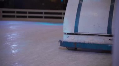 31 Aralık 2020. Ukrayna. Kiev. Akşamları buz pateni pistinde buz pateni pisti seviyesine getirecek makinede çalışan işçiler. Buz pateni pistinde buzu parlatma işlemi. Buz kıracağı hareket halindeyken paten pistine çıkıyor.