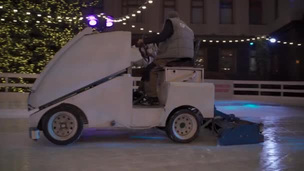 2020年12月31日 ウクライナだ キエフ スケート場で夜に氷の表面リンクをレベルにマシン上の労働者新年フェア アイスリンクに氷を研磨するプロセス 氷のカッターがグライドリンクを作る — ストック動画