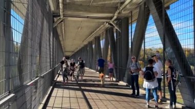 16 Ekim 2022. Münih, Almanya. Munchen 'den Grosshesseloher Köprüsü' ne. Yayalar ve bisikletçiler, güneşli havada Deutschland 'daki Isar Nehri üzerinde yüksek köprüden geçerler. Yürüyüşçüler ve bisikletçiler köprüde. 