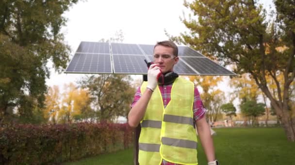 Inżynier Elektrowni Słonecznej Noszący Kask Bezpieczeństwa Przed Panelami Słonecznymi Używa — Wideo stockowe