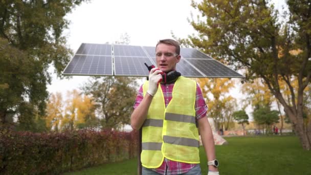 Szef Projektu Słonecznego Noszący Twardy Kapelusz Przed Panelami Słonecznymi Rozmawiający — Wideo stockowe