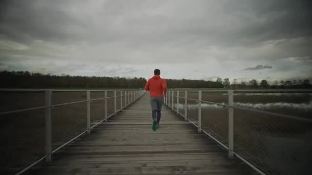 Homem Capuz Laranja Correndo Através Parque Nacional Através Ponte Madeira — Vídeo de Stock